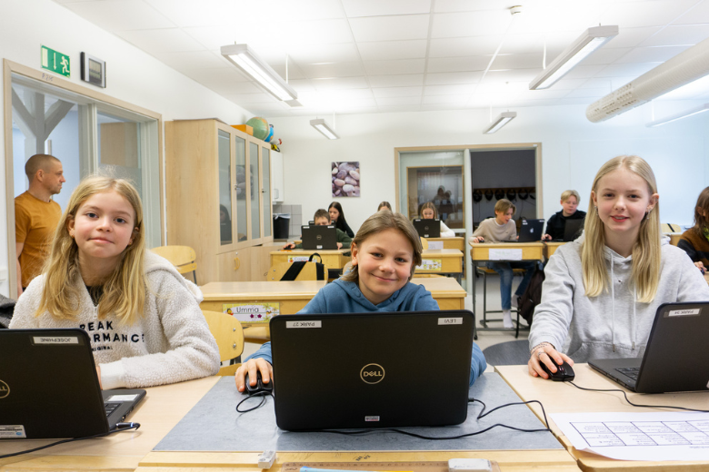 Josephine, levi och tilda sitter vid skolbänkar med datorerna framför sig