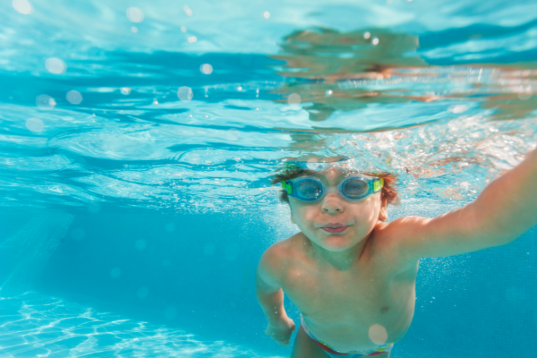 Bild tagen under vatten på pojke som simmar