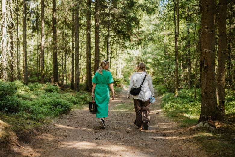 Två personer går på en stig i skogen