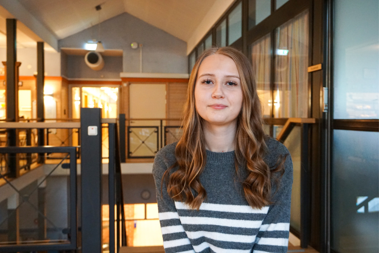 Matilda Persson sitter vid bord i cafeterian på Ekbackeskolan
