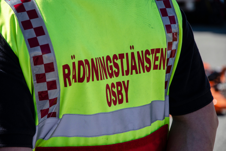 Person bär en gul väst där det står Räddningstjänsten Osby på ryggen
