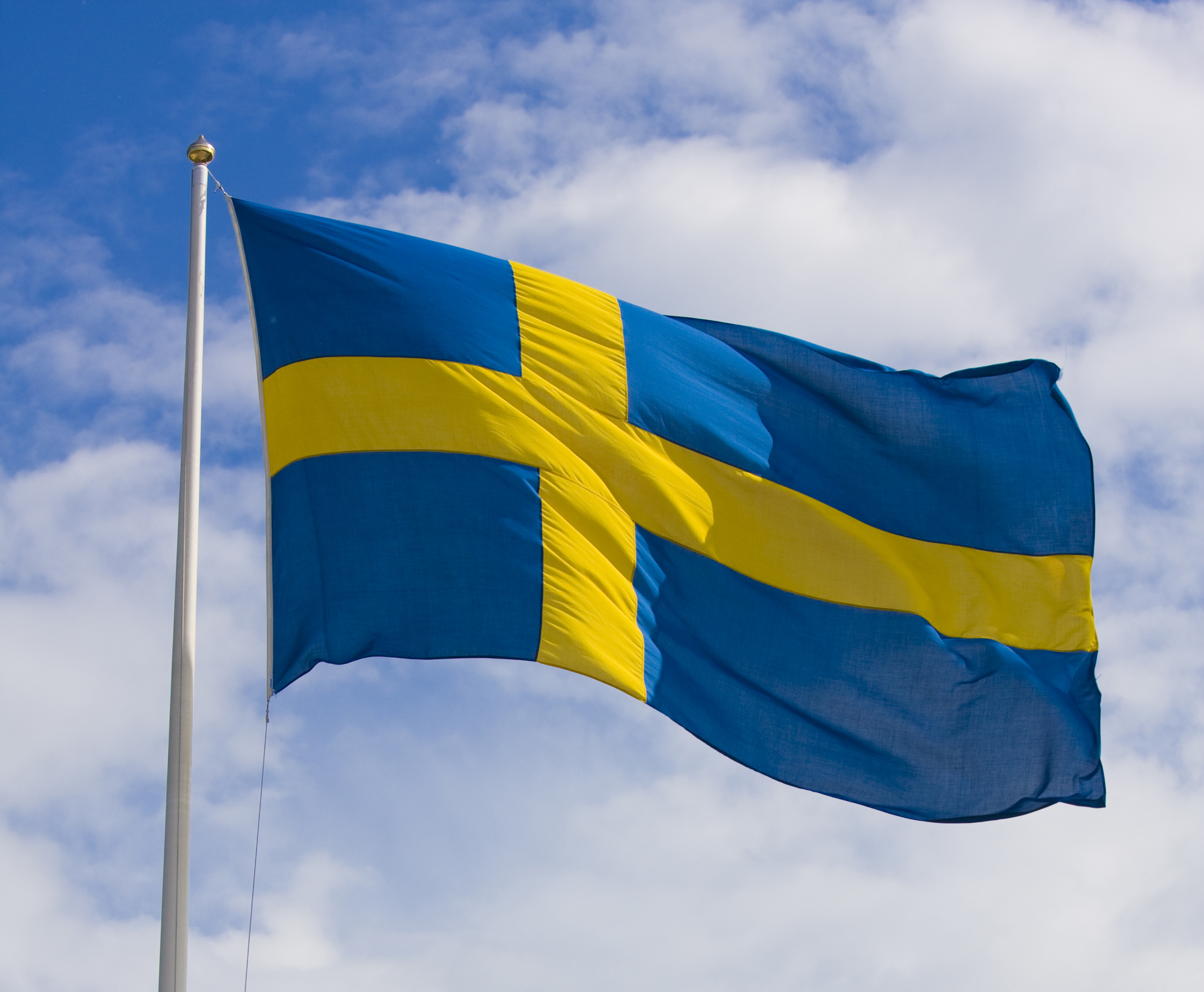 Svensk flagga hissad mot blå himmel