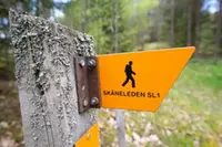 En trästolpe med en gul skylt på.